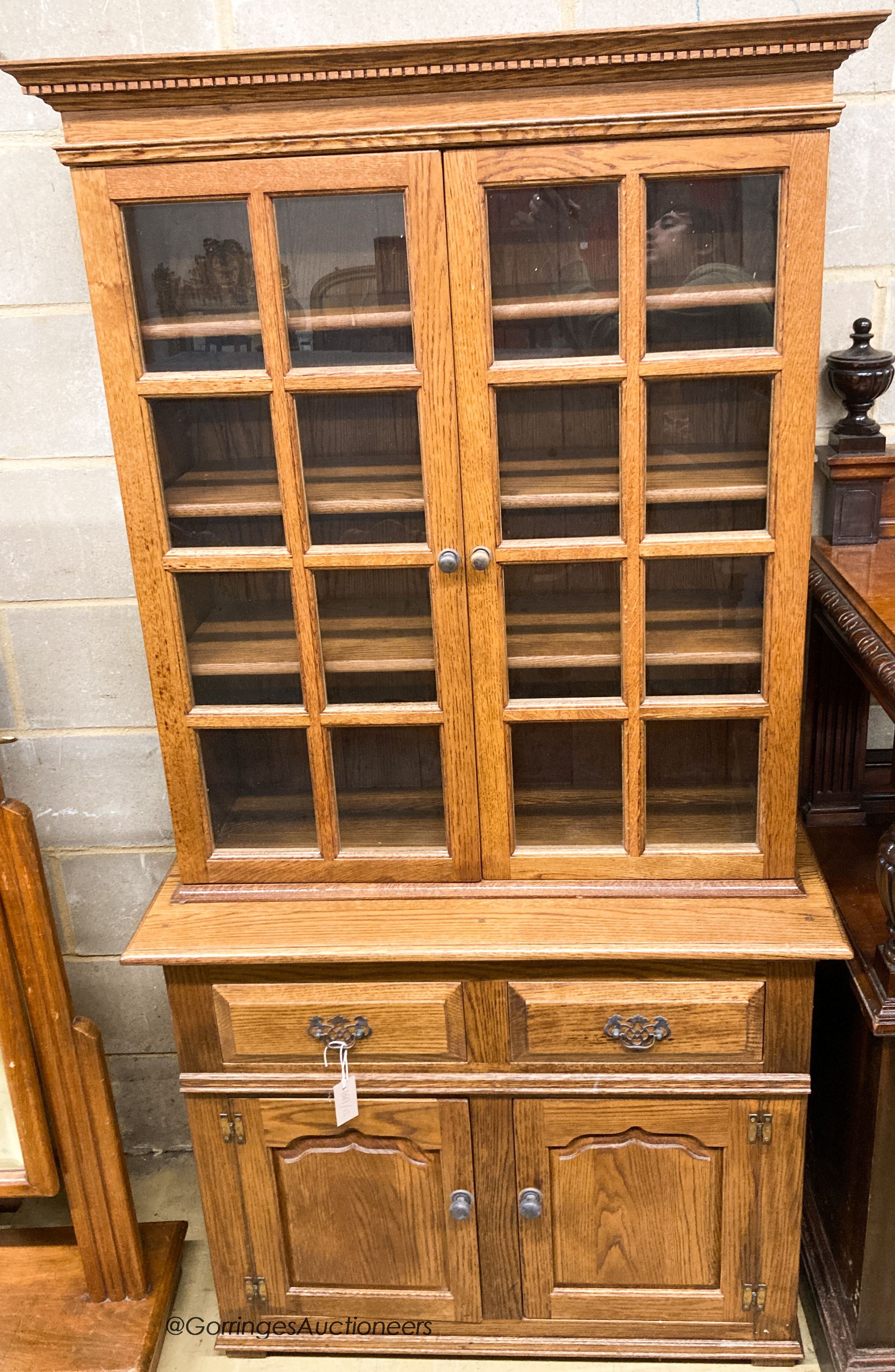 A reproduction oak bookcase cupboard, width 97cm, depth 43cm, height 190cm